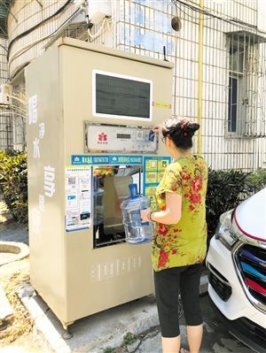 5月24日，瓊山區上丹花苑小區居民陳女士在使用共享凈水機取水。 本報記者 陳歆卓 攝