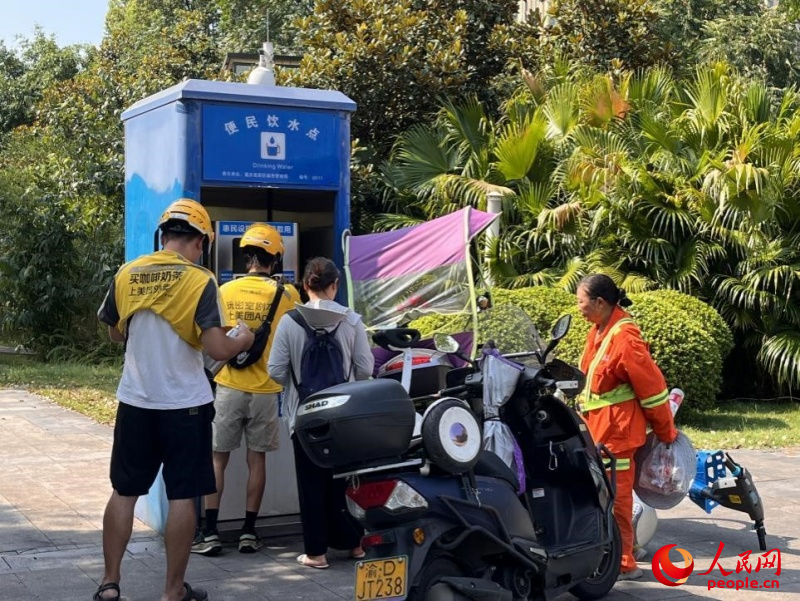 9月5日，正在“0011”號(hào)便民飲水點(diǎn)排隊(duì)接水的市民。周小平攝